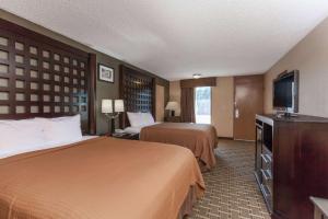 a hotel room with two beds and a flat screen tv at Super 8 by Wyndham Atoka in Atoka