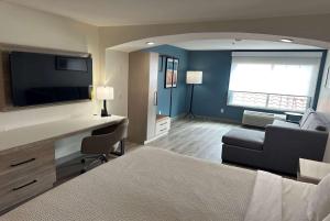 a hotel room with a bed and a desk with a television at La Quinta by Wyndham Albuquerque Midtown NEWLY RENOVATED in Albuquerque