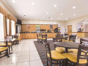 a restaurant with tables and chairs and a kitchen at La Quinta by Wyndham Alvarado in Alvarado