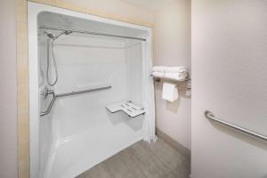 a bathroom with a shower with towels in it at Days Inn & Suites by Wyndham San Antonio near Frost Bank Center in San Antonio +49 photos