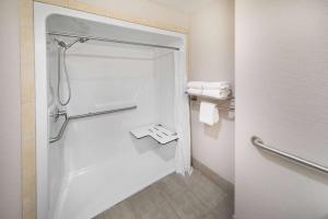 een badkamer met een douche en handdoeken. bij Days Inn & Suites by Wyndham San Antonio near Frost Bank Center in San Antonio