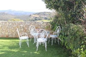 un grupo de sillas y una mesa en un patio en CASA MARGARITA, en El Castillo de las Guardas