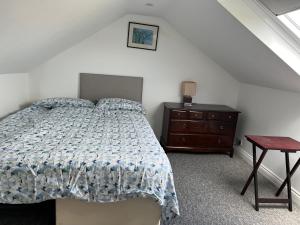 a bedroom with a bed and a dresser and a table at 200m To Botanical Garden 3 Bedroom Victoria House in Cambridge