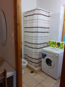 a bathroom with a washing machine and a toilet at Agios Petros Studio in Áyios Pétros