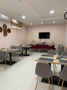 uma sala de jantar com mesas e cadeiras e uma televisão em Готель Едем em Hadyach