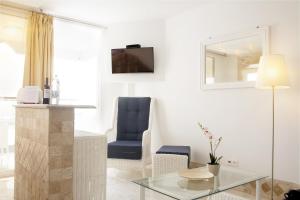 a living room with a glass table and a blue chair at Villa Magna in Puerto Rico de Gran Canaria