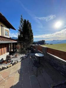 eine Terrasse mit einem Tisch, einem Tisch und Stühlen in der Unterkunft Ferienhaus Praschberg in Niederndorferberg