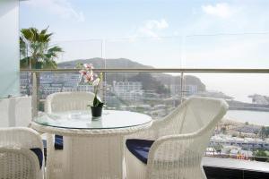 een tafel en stoelen met uitzicht op de oceaan bij Villa Magna in Puerto Rico de Gran Canaria