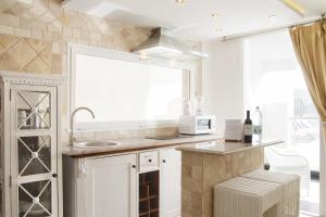 a kitchen with white cabinets and a sink and a window at Villa Magna in Puerto Rico de Gran Canaria