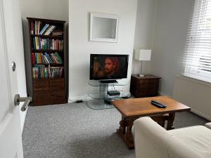 a living room with a television and a coffee table at 200m To Botanical Garden 3 Bedroom Victoria House in Cambridge