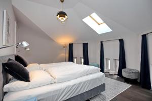 - une chambre avec un grand lit blanc et des oreillers noirs dans l'établissement Villa Greif Wohnung 05, à Heiligendamm