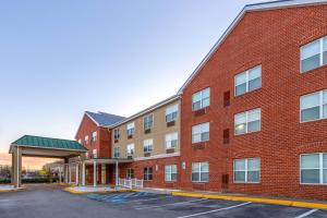 a large red brick building with a parking lot at Wingate by Wyndham Waldorf - Washington DC Area in Waldorf
