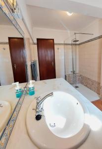 a bathroom with a white sink and a shower at Hakuna matata in Benagil