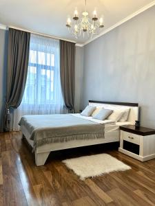 a bedroom with a large bed and a chandelier at Lux apartments in the city center, with a view of the theater, near Zlata Plaza in Rivne