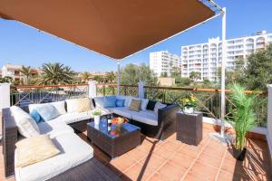 patio con divani, tavolo e ombrellone di Moderne Villa, Pool+Meerblick,schnelles Wifi,Klima a Calas de Mallorca