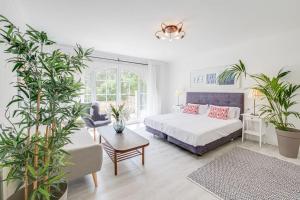 una camera con letto, tavolo e piante di Moderne Villa, Pool+Meerblick,schnelles Wifi,Klima a Calas de Mallorca