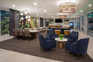 a lobby with blue chairs and tables and a restaurant at La Quinta Inn & Suites by Wyndham Galt Lodi North in Galt