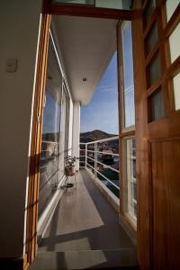 um quarto com uma varanda com uma porta e uma janela em Amarus Apartment em Cusco