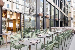 un restaurante con mesas, sillas y ventanas en Hotel Yac Paris Clichy, a member of Radisson Individuals en Clichy