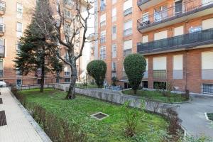 um parque em frente a um edifício com árvores e arbustos em Dergano Comfy Apartment - 250 m far from M3 em Milão