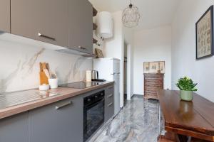 uma cozinha com electrodomésticos brancos e uma bancada de madeira em Dergano Comfy Apartment - 250 m far from M3 em Milão
