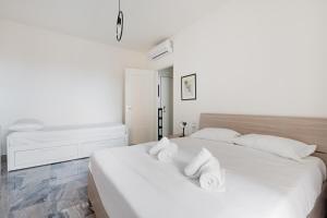 um quarto branco com 2 camas e almofadas brancas em Dergano Comfy Apartment - 250 m far from M3 em Milão
