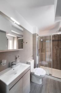 a bathroom with a toilet and a sink and a shower at Boursinos cozy apartments by Imagine Lefkada in Lefkada Town