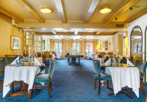 Hotel Menstrup Kro في Menstrup: غرفة طعام مع طاولات وكراسي وطاولة