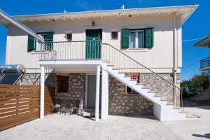 una casa con escalera y persianas verdes en Boursinos cozy apartments by Imagine Lefkada, en Lefkada