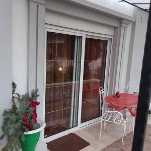 a screened in porch with a red table and chair at Vila Kraljica in Vrdnik