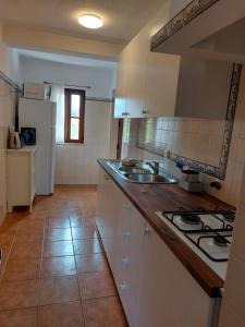 a kitchen with a sink and a stove top oven at Hakuna matata in Benagil