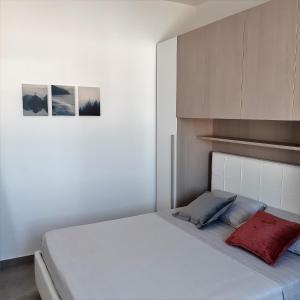 a bedroom with a white bed with a red pillow at VILLETTA A 40 PASSI DAL MARE GALLIPOLI in Marina di Mancaversa