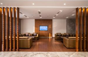 a waiting room with couches and a flat screen tv at Ratnamouli Palace in Guwahati