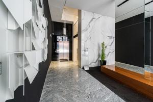 a hallway with white walls and marble floors at Baltiq Plaza - BillBerry Apartments in Gdynia