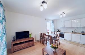 ein Wohnzimmer mit einer Küche und einem Tisch mit Stühlen in der Unterkunft Marel-Apartments Willa Fonte - apartament 8 in Polanica-Zdrój