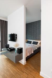 a bedroom with a bed and a table and a tv at Baltiq Plaza - BillBerry Apartments in Gdynia