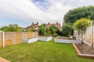 a garden with two raised beds in a backyard at Broadstairs Family Home in Kent