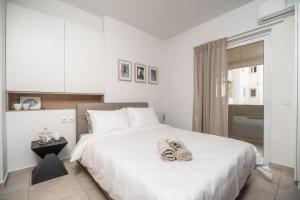 a bedroom with a bed with a pair of shoes on it at City Beach Apartment in Chania Town