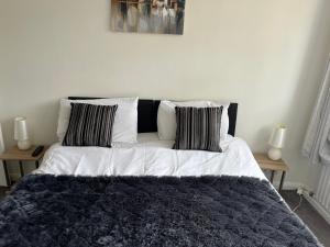 uma cama branca com duas almofadas em cima em A Home from Home em Ascot