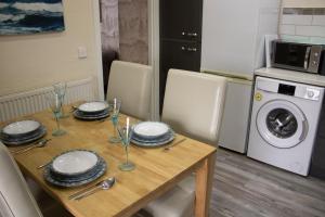 a dining room table with plates and wine glasses on it at Buttermere Cottage in Banff