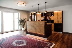 a living room with a wooden counter and a rug at KOASA HOF Bed and Breakfast in Oberhaag