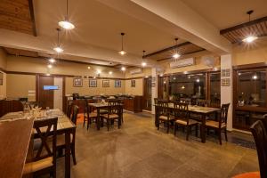 Blackbuck Safari Lodge Velavadar في Velavadar: مطعم فيه طاولات وكراسي في الغرفة