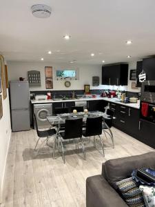 a kitchen with a table and chairs in a room at The Cabin, Arkley, Barnet in Barnet