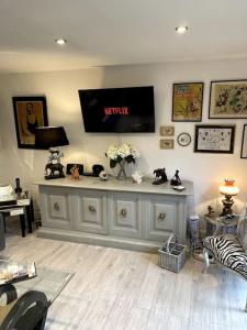 a living room with a tv on the wall at The Cabin, Arkley, Barnet in Barnet