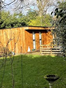 a wooden building with a fence in a yard at The Cabin, Arkley, Barnet in Barnet