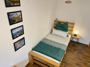 a small bed in a room with pictures on the wall at Ferienwohnung Melise in Reutte