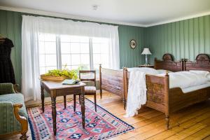 - une chambre avec 2 lits, une table et une fenêtre dans l'établissement Herregården Hoel - De Historiske, à Nes i Ådal