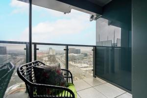 a chair on a balcony with a view of a city at 16th Floor Towarowa 39 City Center Avenida by Renters Prestige in Poznań