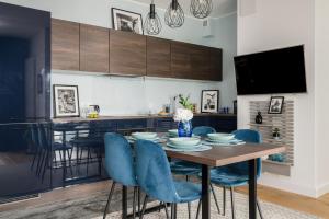 a dining room with a table and blue chairs at 16th Floor Towarowa 39 City Center Avenida by Renters Prestige in Poznań
