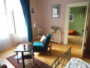 a living room with a blue chair and a table at Appartment Nezamyslova II in Prague
